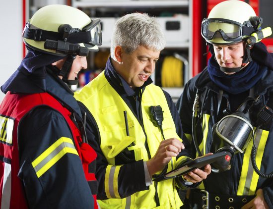 Feuerwehrleute mit Tablet bei einer Einsatzbesprechung